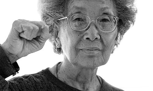 Portrait of Yuri Kochiyama with raised fist.